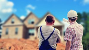 Arhitekta i radnik diskutuju gledajući ka kućama
