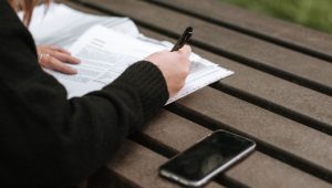 Žena piše na klupi