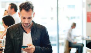 Čovek u čekaonici gleda u telefon