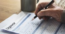 pensioner-filling-out-a form penzioner potpisuje ugovor olovka papir ruka stariji čovek