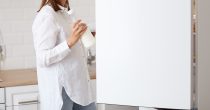 Žena u kuhinji vadi mleko iz frižidera