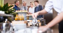 four-smiling-business-people-buffet-table