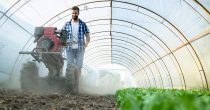 hardworking-young-farmer-operating-motor-cultivator-prepare-soil-new-seedlings-organic-food-farm